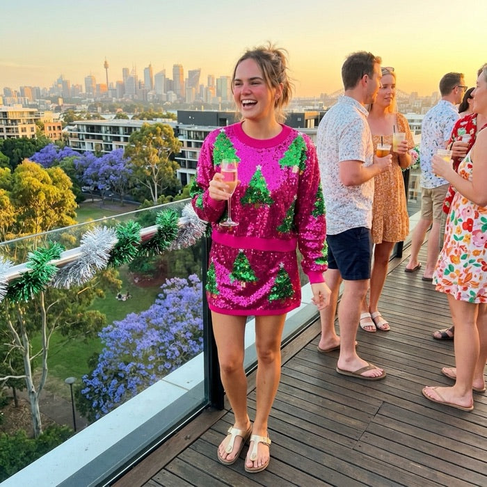 Woman in a sequined Christmas tree two-piece set at rooftop drinks on Christmas Eve